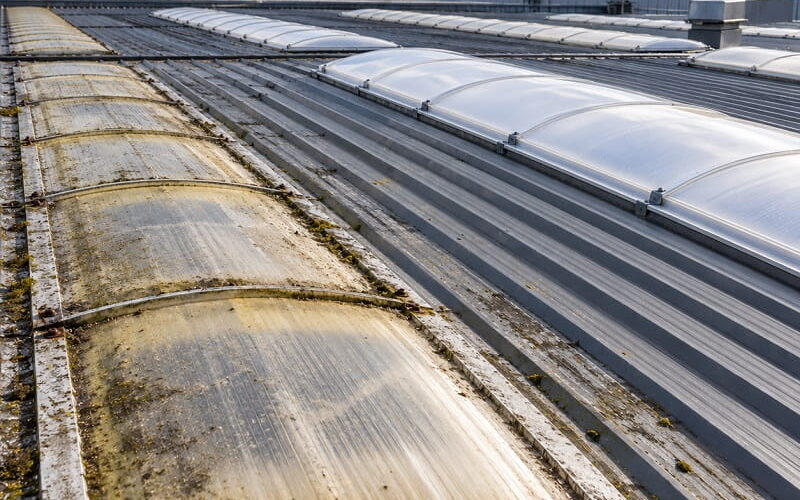 Ageing and newer industrial rooflights showing the difference between deteriorated and replacement rooflights.